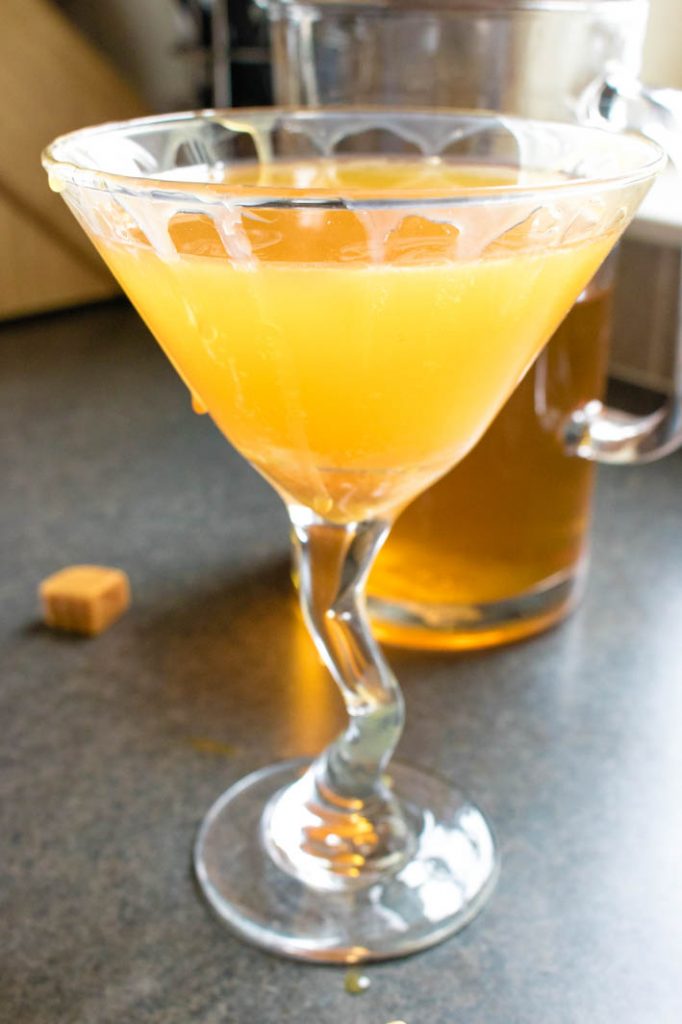Caramel Apple-tea-ni in pretty martini glass, with pitcher of cocktail behind